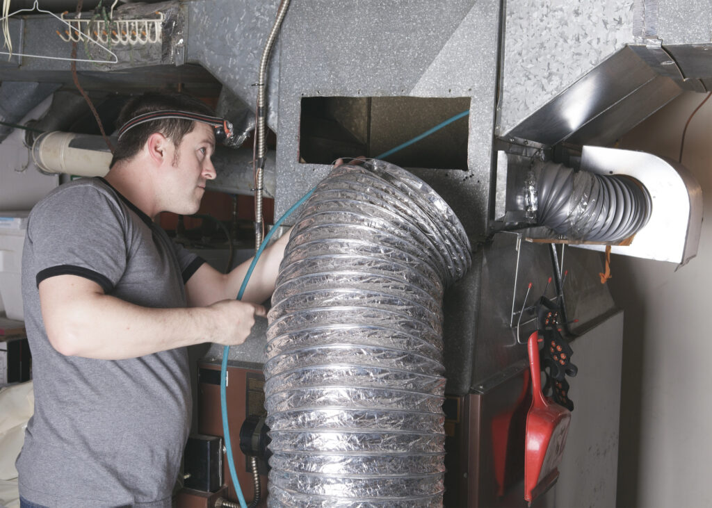 A ventilation cleaner man at work with tool 