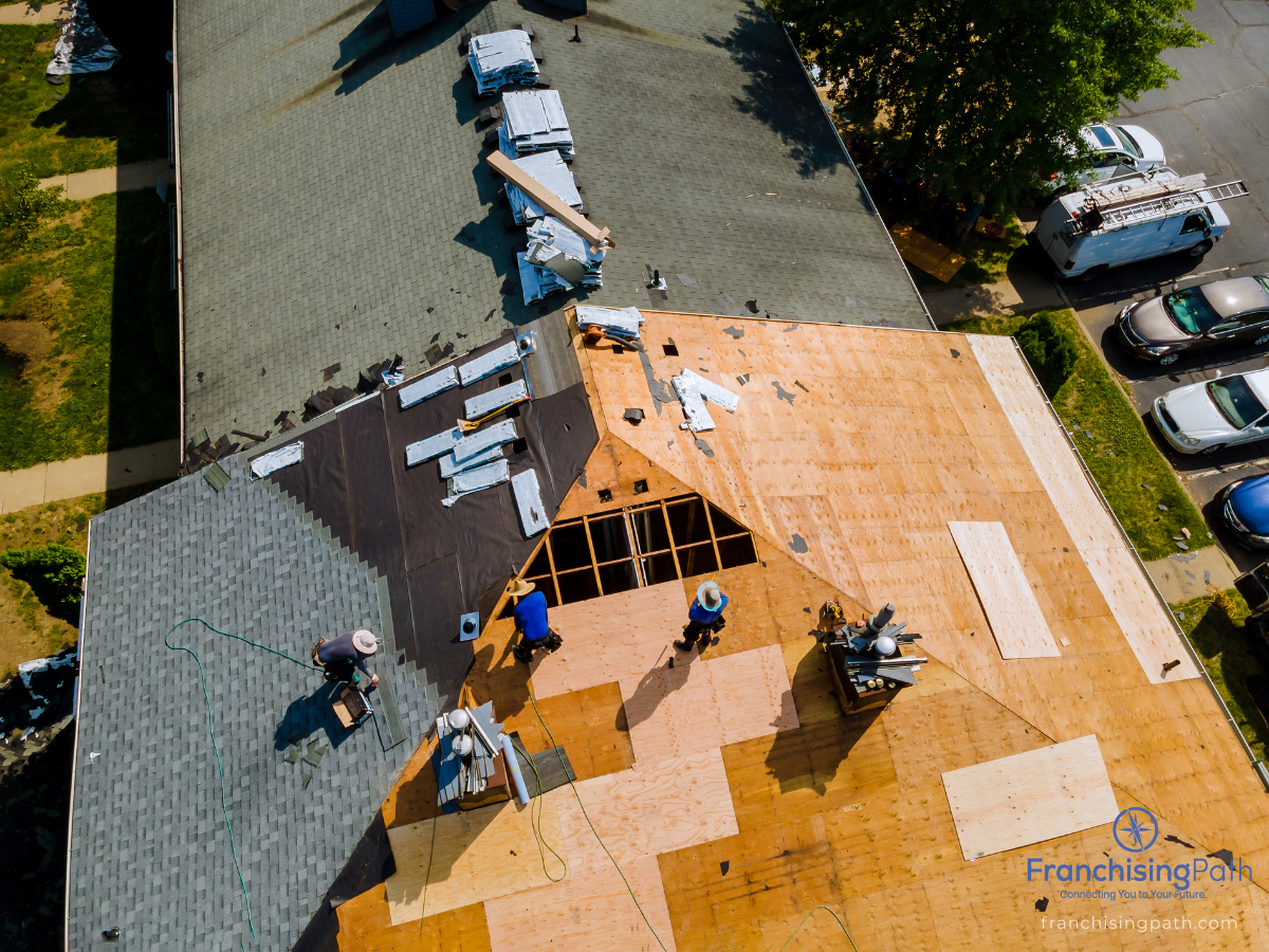 Aerial view of roofing professionals restoring a residential roof using advanced materials